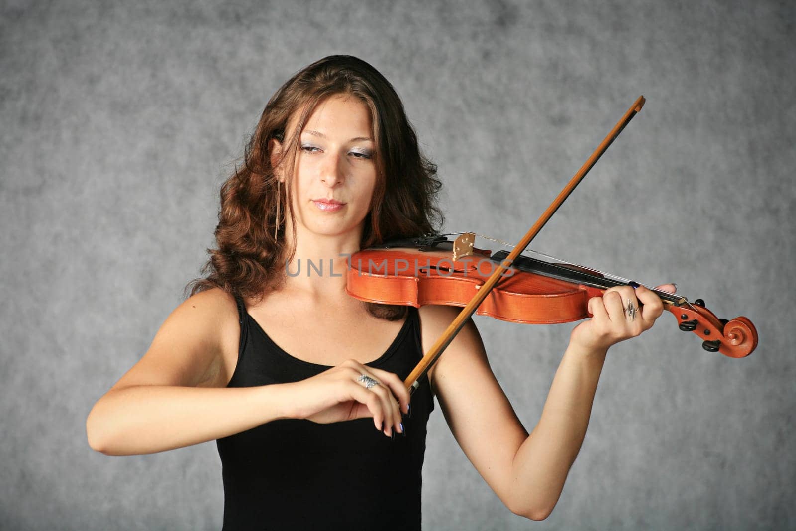 portrait of sexy brunette with violin on the grey background