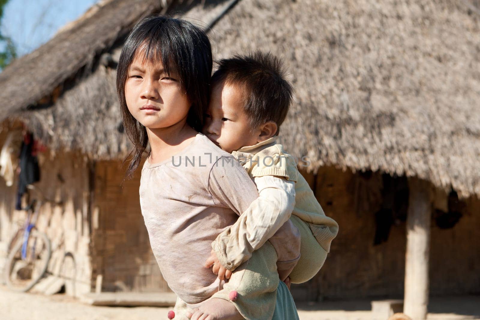 Children in poverty,sister has little brother piggybacking