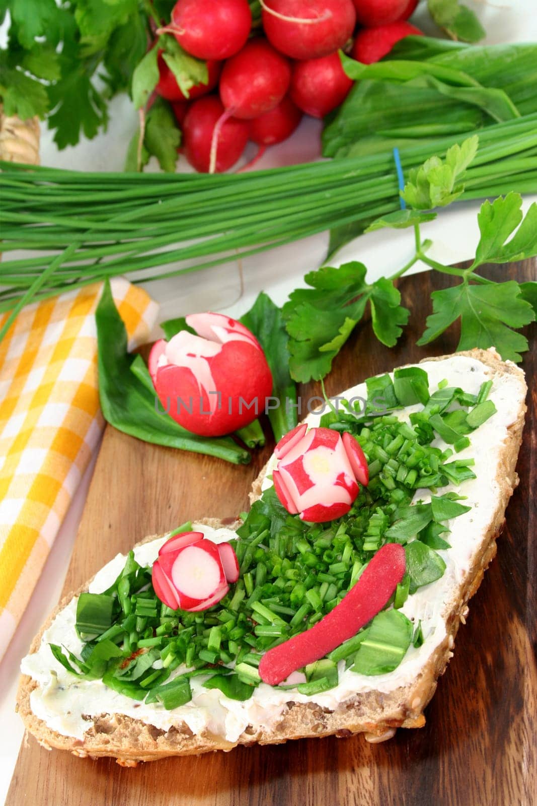 a roll topped with cream cheese,chives and fresh wild garlic