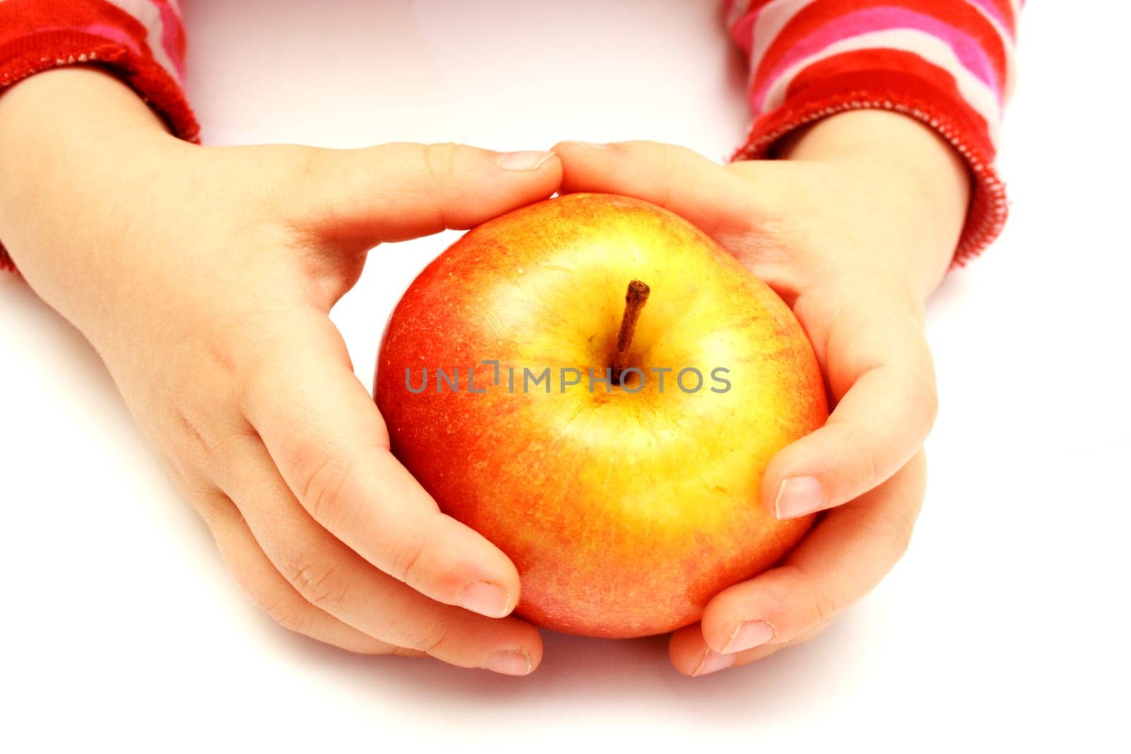 child is holding fresh apple on hands