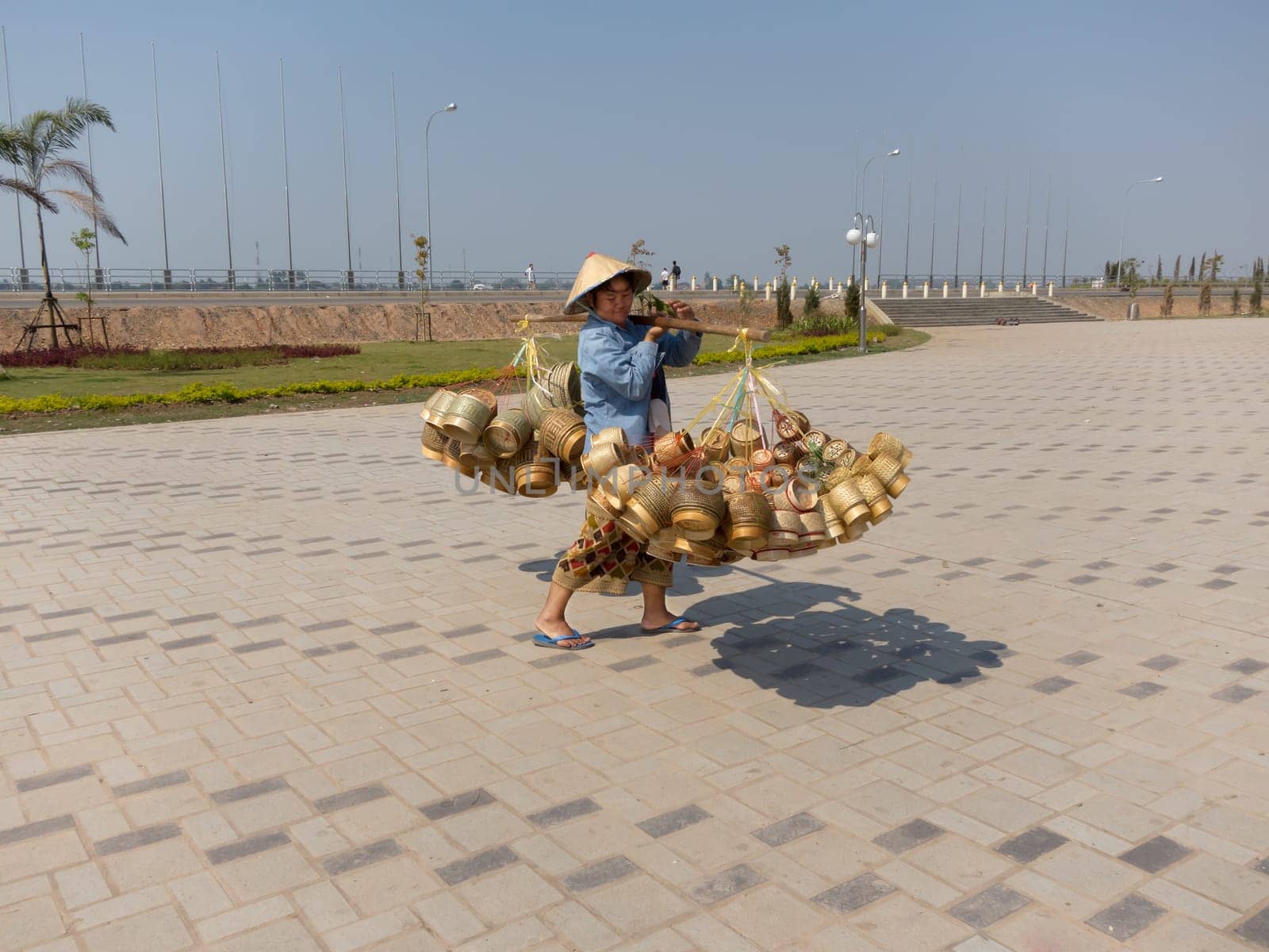 Street vendor Laos,heavy load with baskets on pole