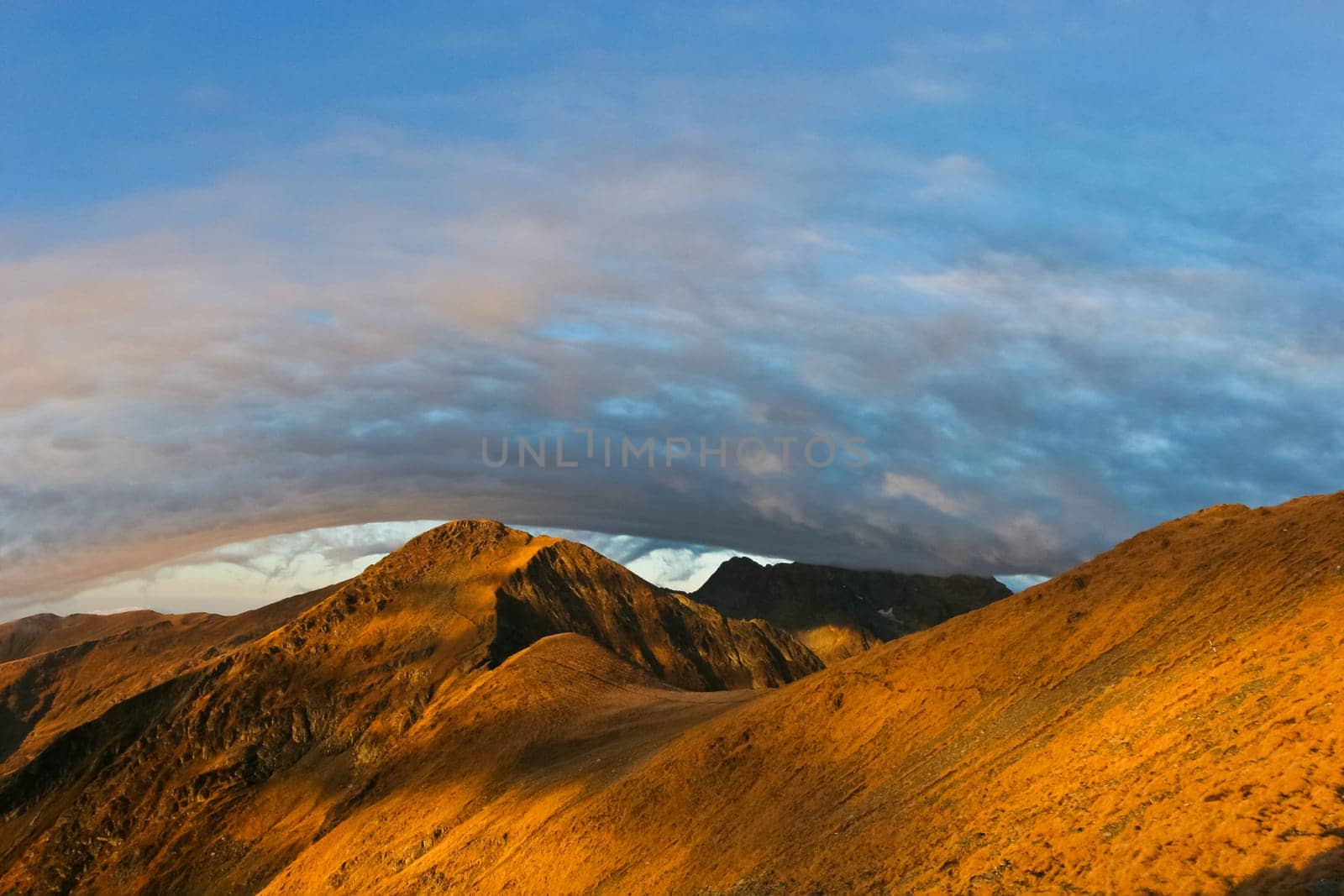 reflection sunrise on a mountain slope under a cloud