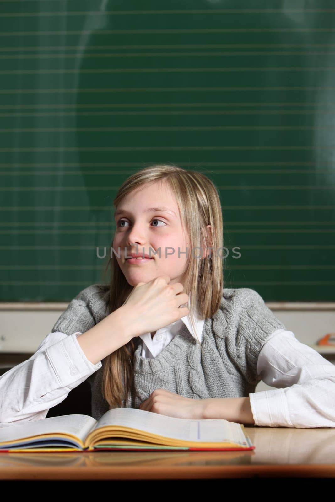 Cheerful child at school with book learning with fun