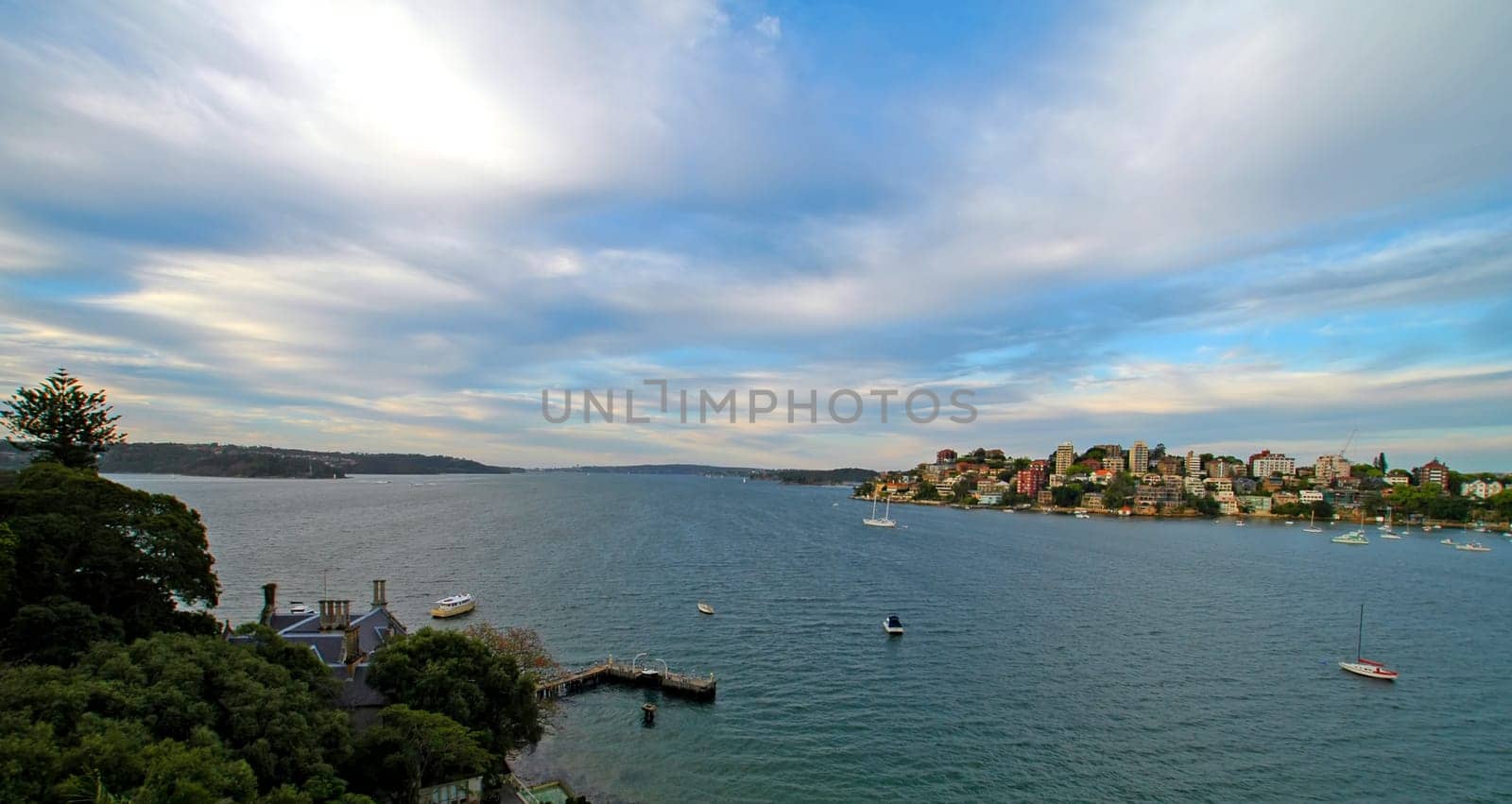 ocean panorama, cloudy sky, water, boats anchoring,