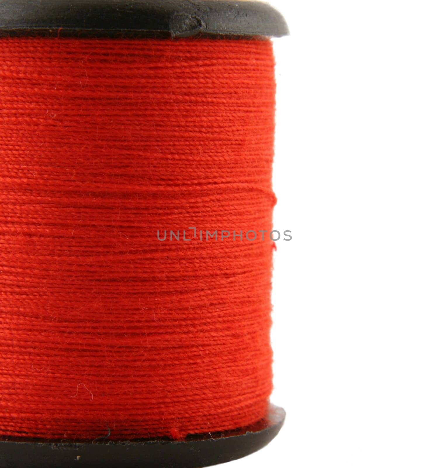 Red spool of thread over white