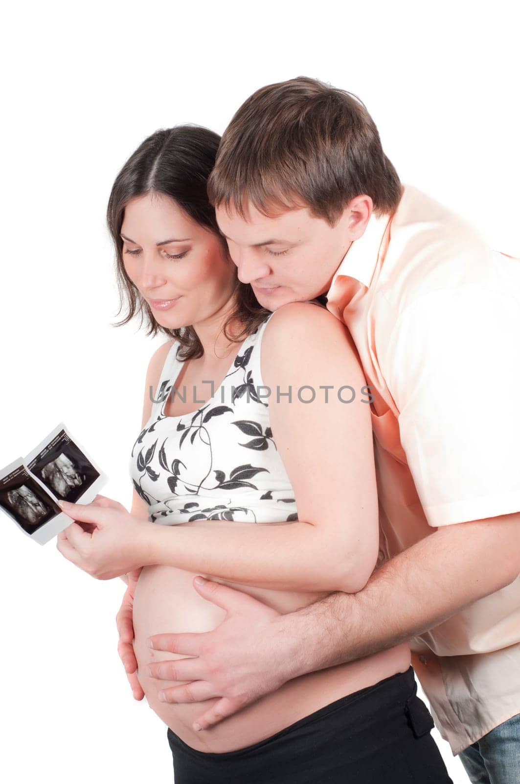 Happy young couple holding a sonogram of their child
