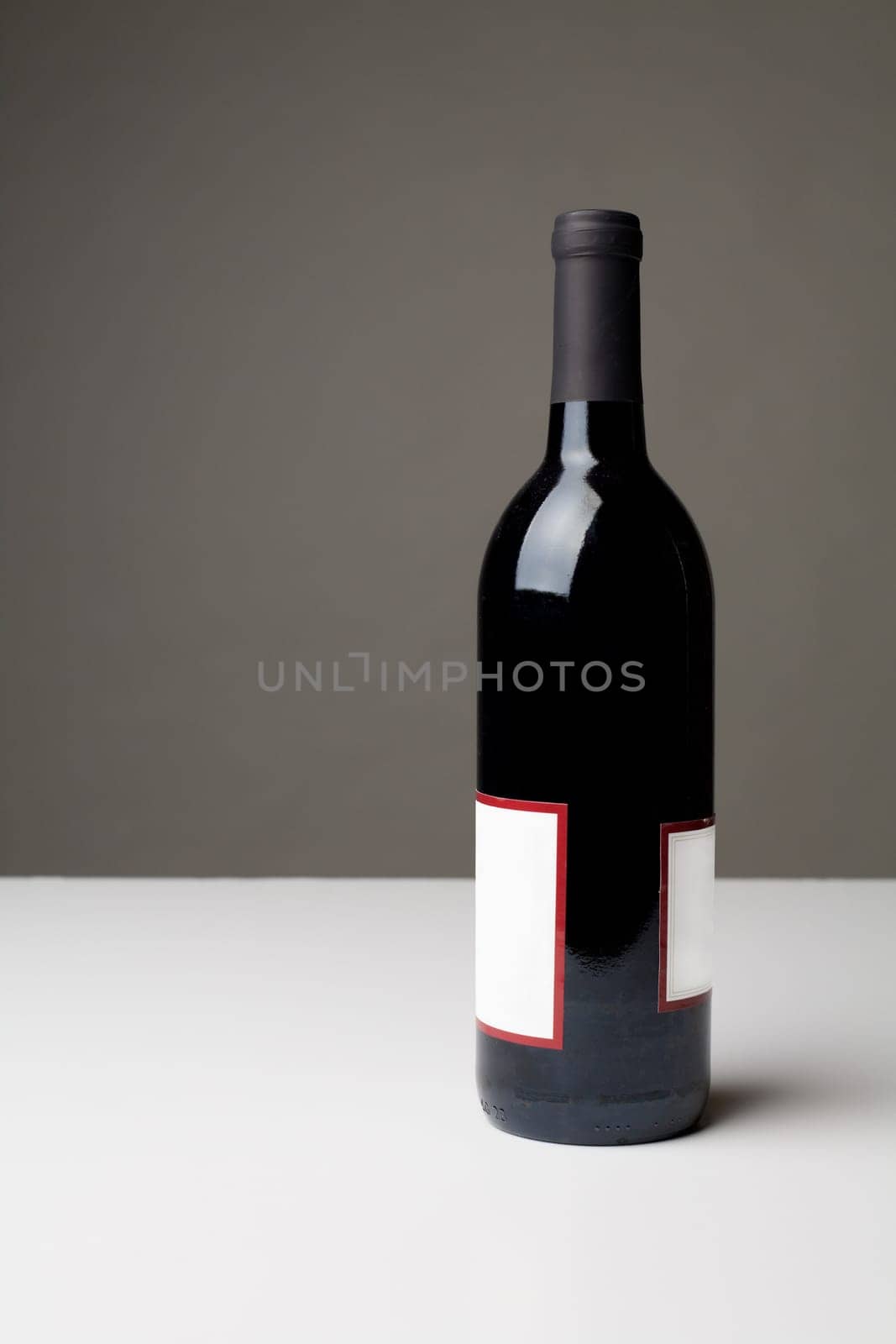 Unopened bottle of red wine on white table