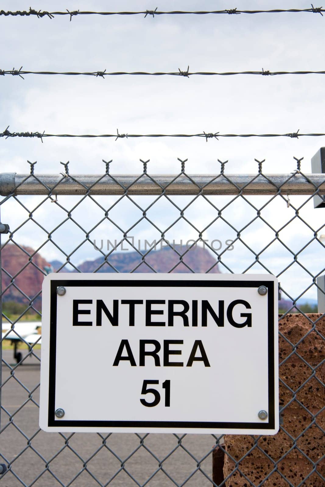 Sign on a chain link fense with barbed wire