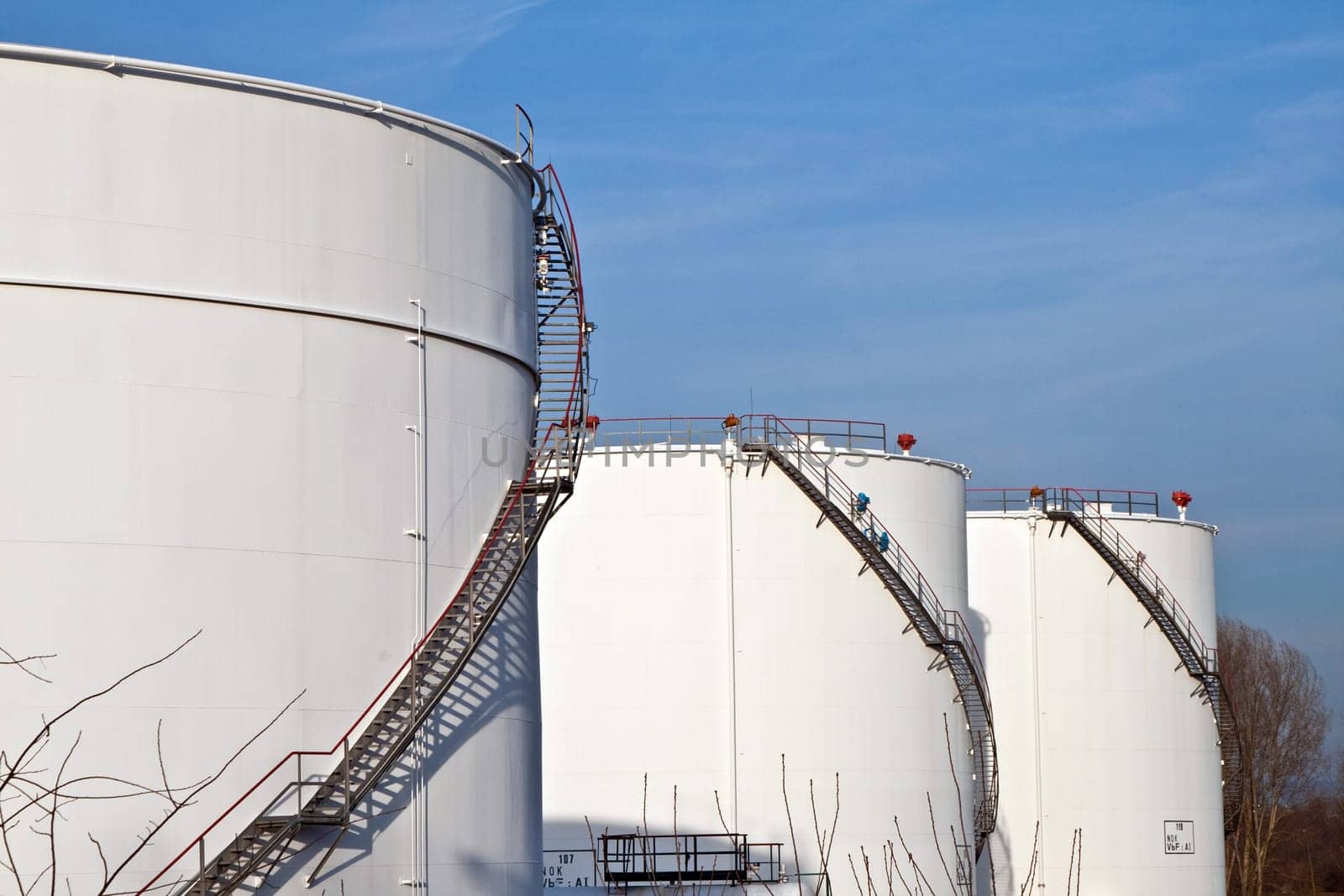 white tanks in tank farm with blue sky