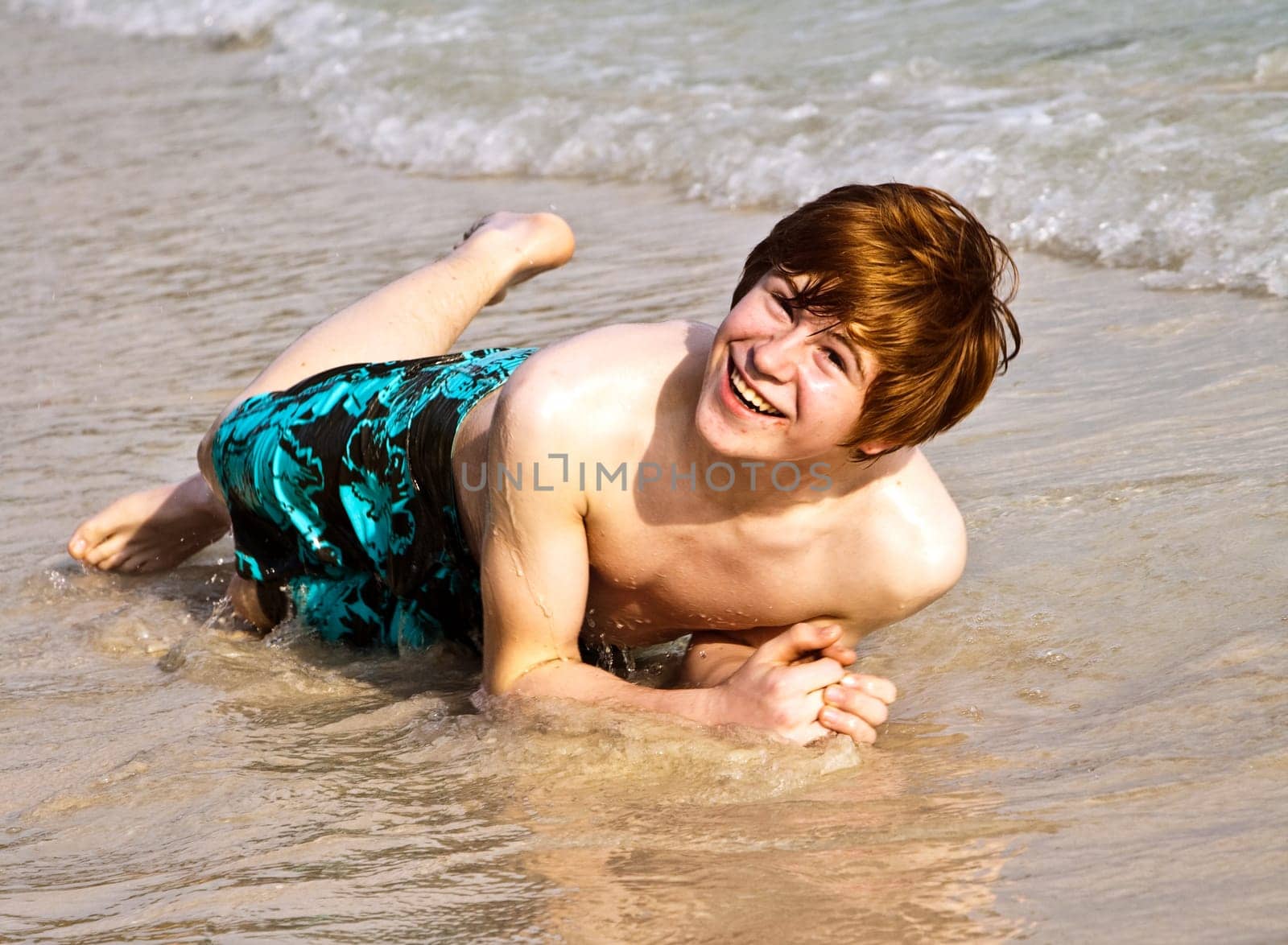 happy boy with red hair is enjoying the beautiful beach