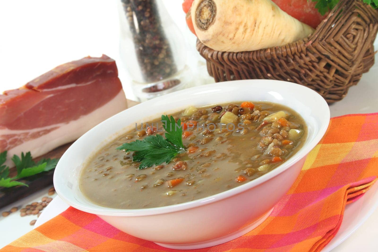 a bowl of lentil soup with bacon and parsley