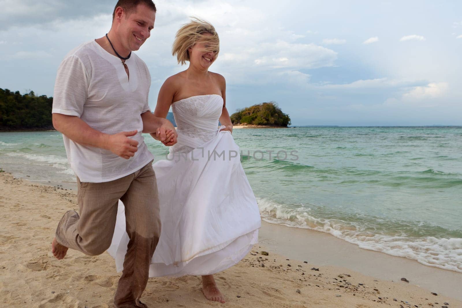 Running on the beach,couple in love on their honeymoon by the sea