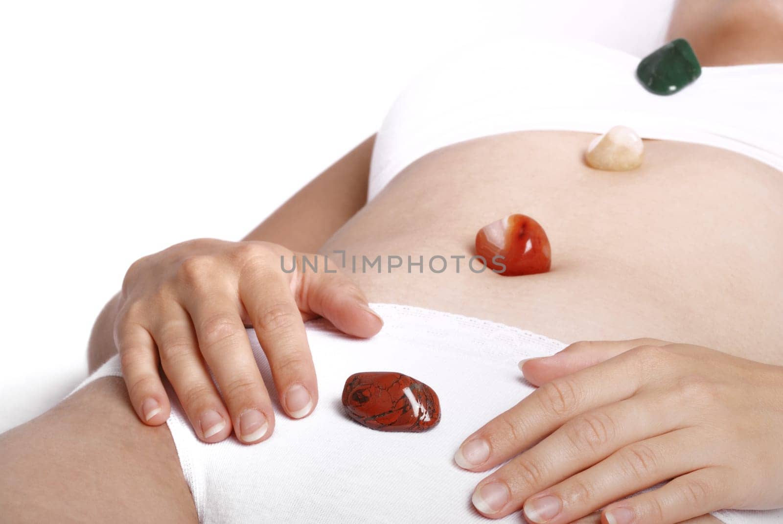 Alternative medicine - healing by semiprecious gems placed on body chakras, shallow depth of field
