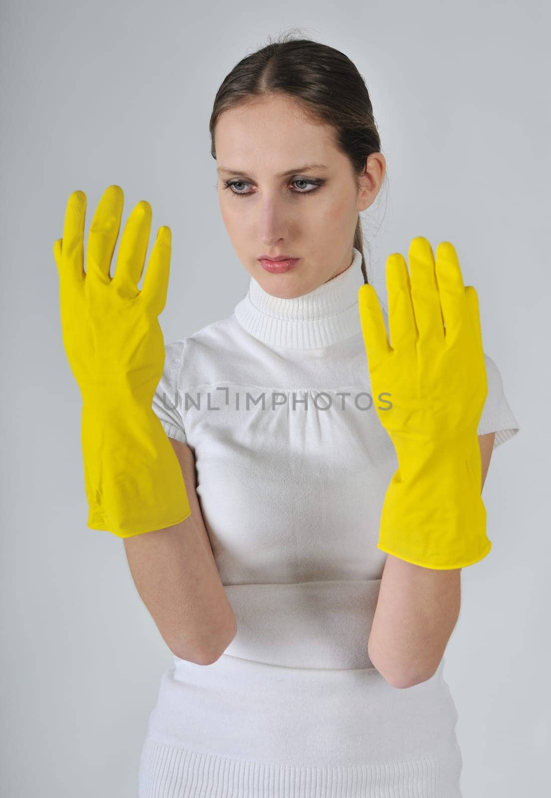 Young woman in yellow working gloves with unhappy expression