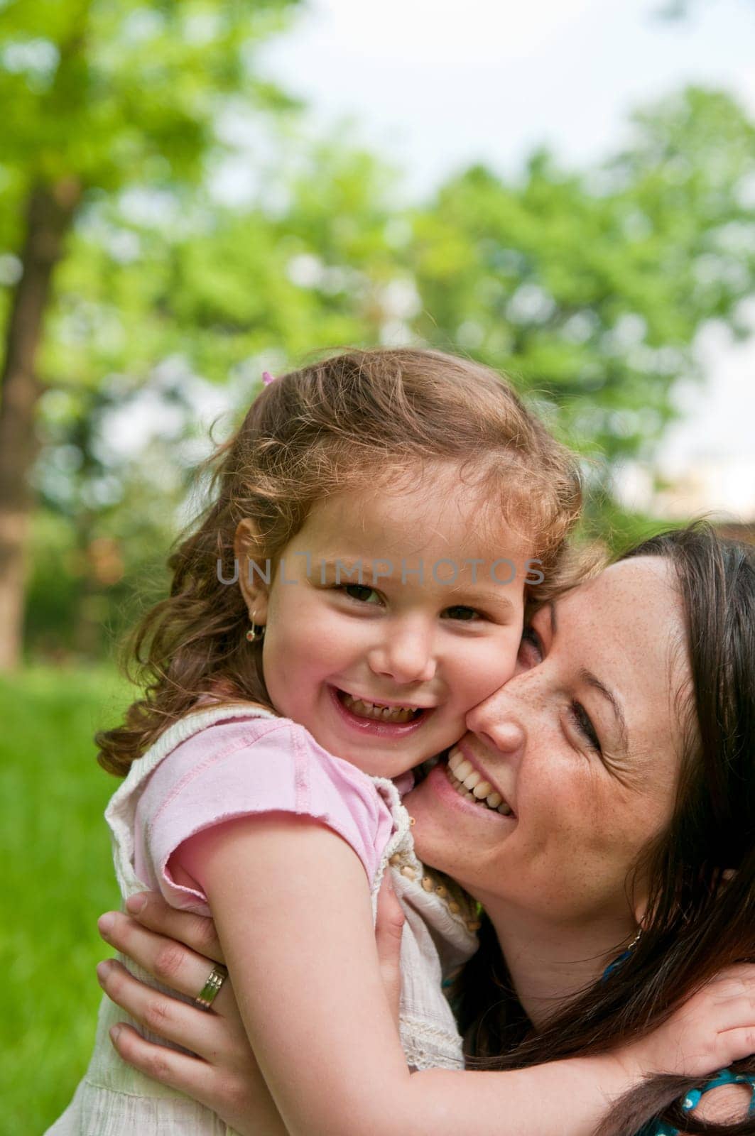 Portrait of small cute girl enjoying life with her mother outdoors