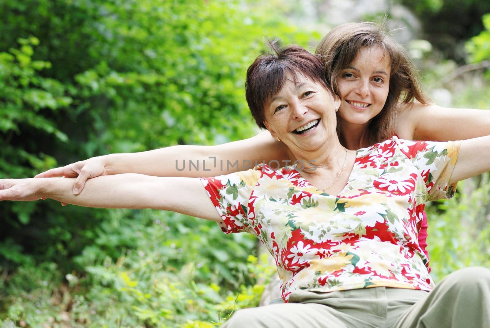 Mature woman has happy time with her daughter in nature