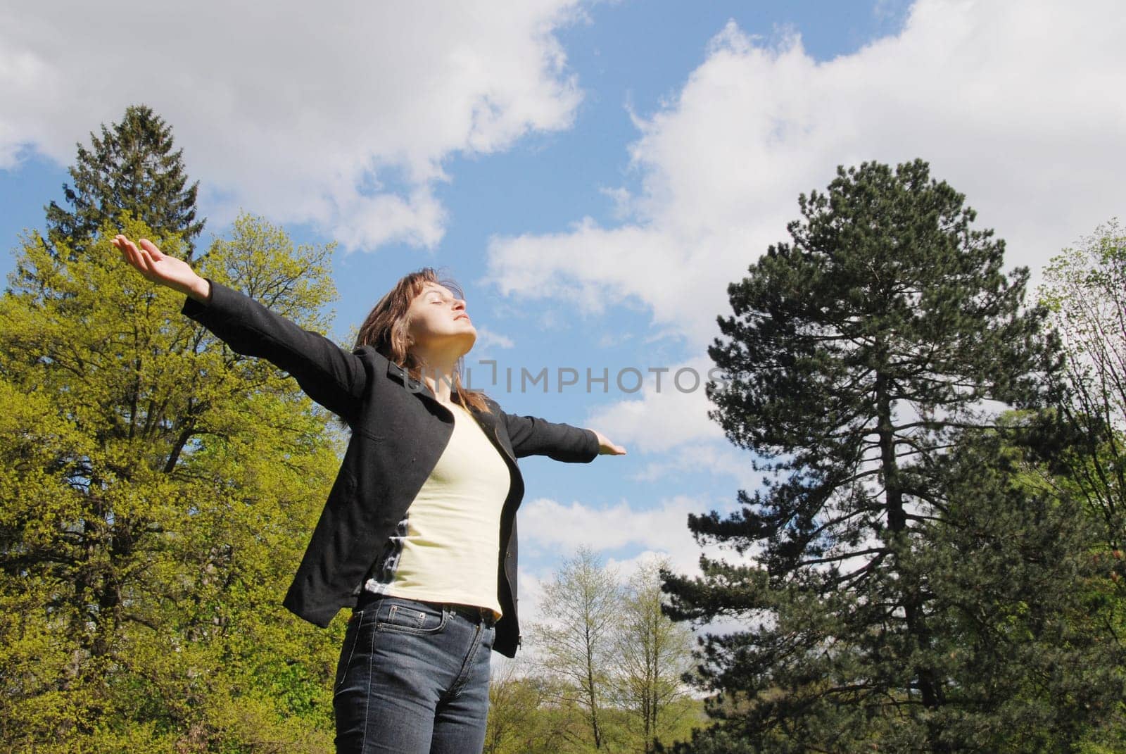 Woman is  enjoying her life outdoors among trees on sun