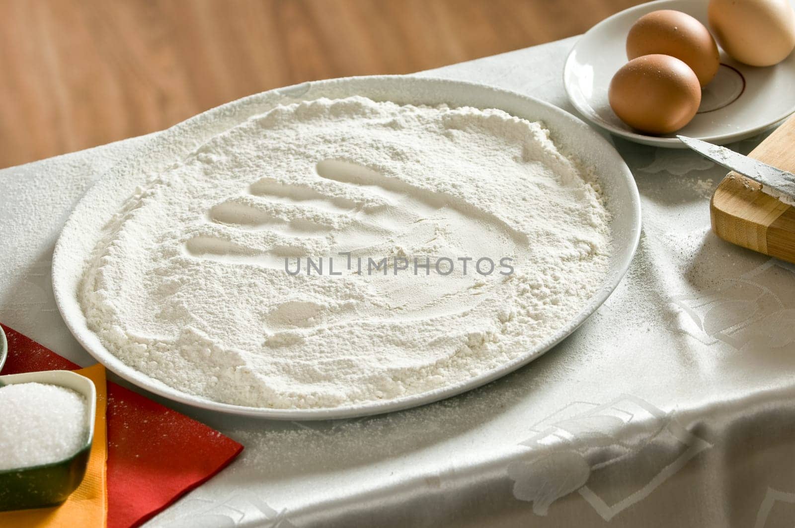 imprint of a woman&#039 s hand in a bowl with the flour