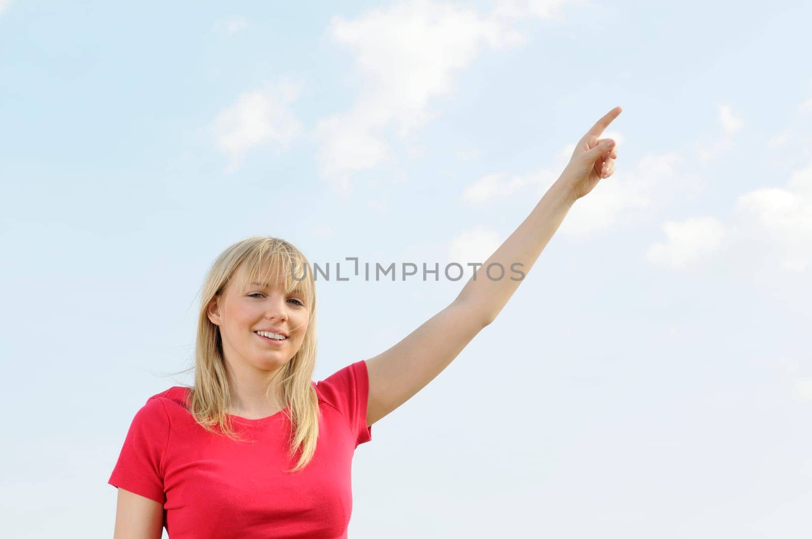 Young woman pointing at the sky