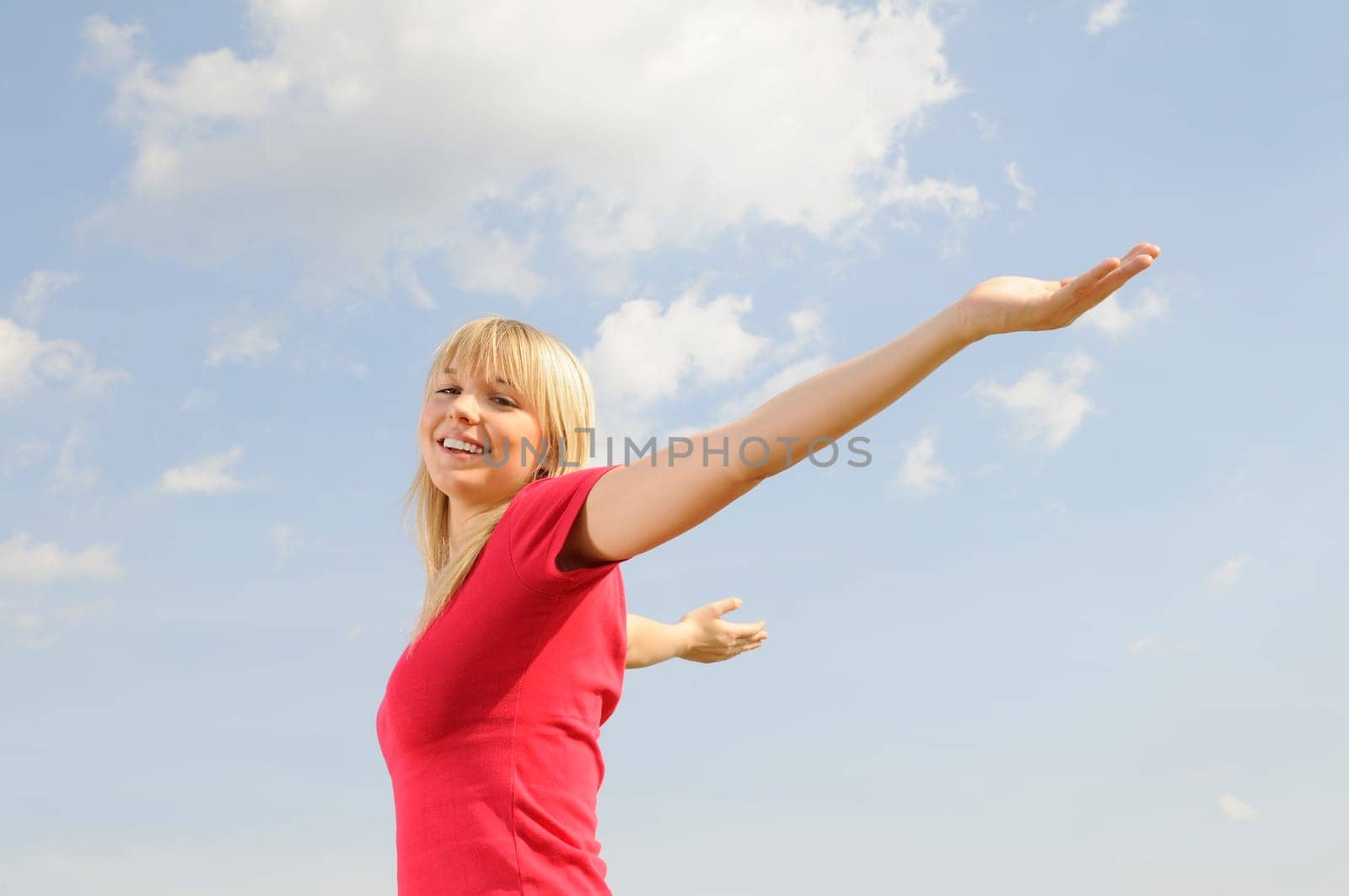 Happy young woman spreads her arms