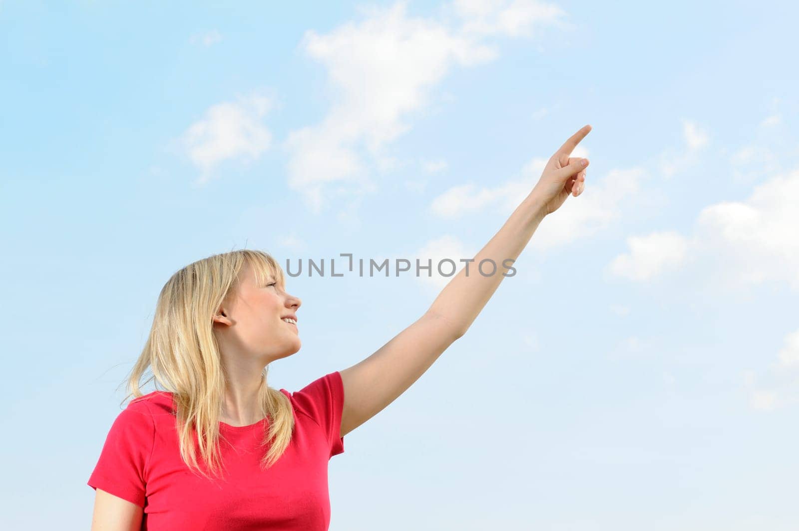 Young woman pointing at the sky
