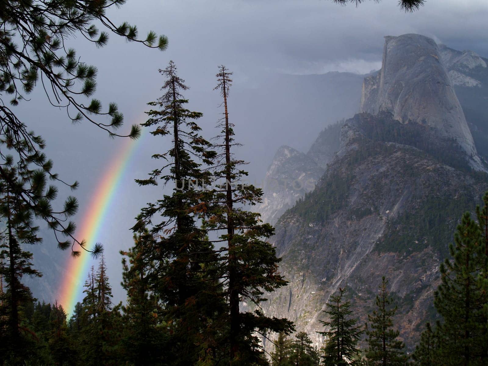 A rainbow in the fog beside half dome in Yosemite National Park, California.
