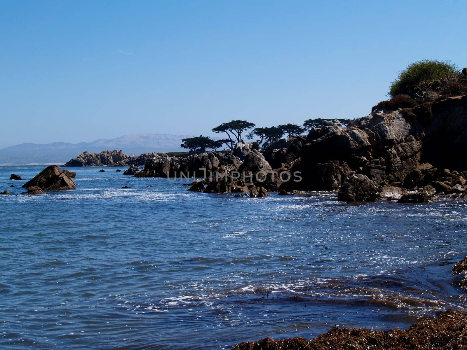 Rocky coast beneath a clear blue sky south of Santa Barbara, California