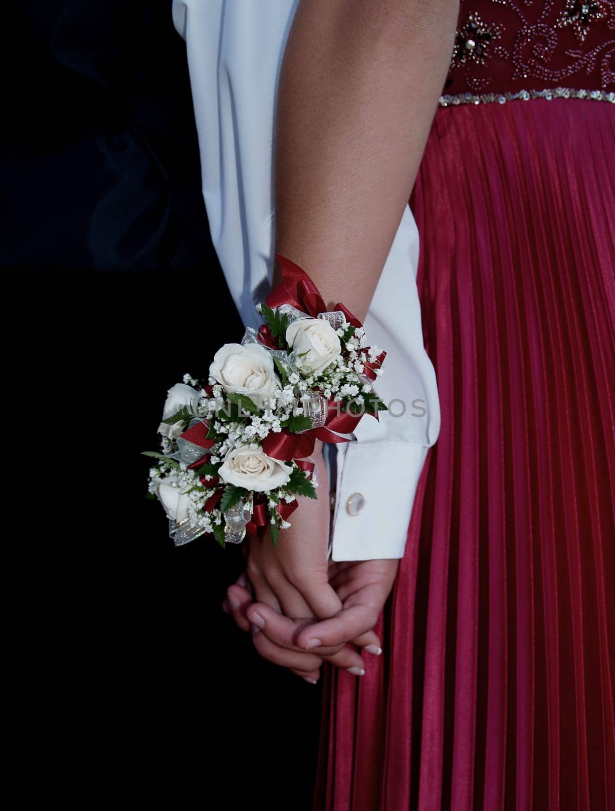 White rose wrist corsage with red ribbon and babies breath.