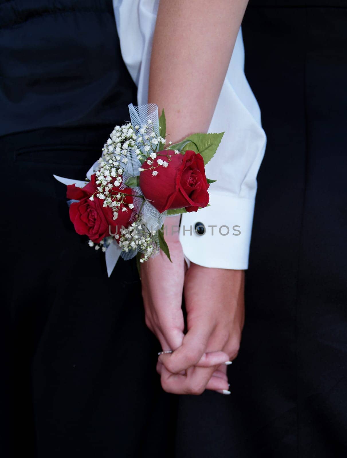 Red rose wrist corsage with babies breath and blue and white ribbons.