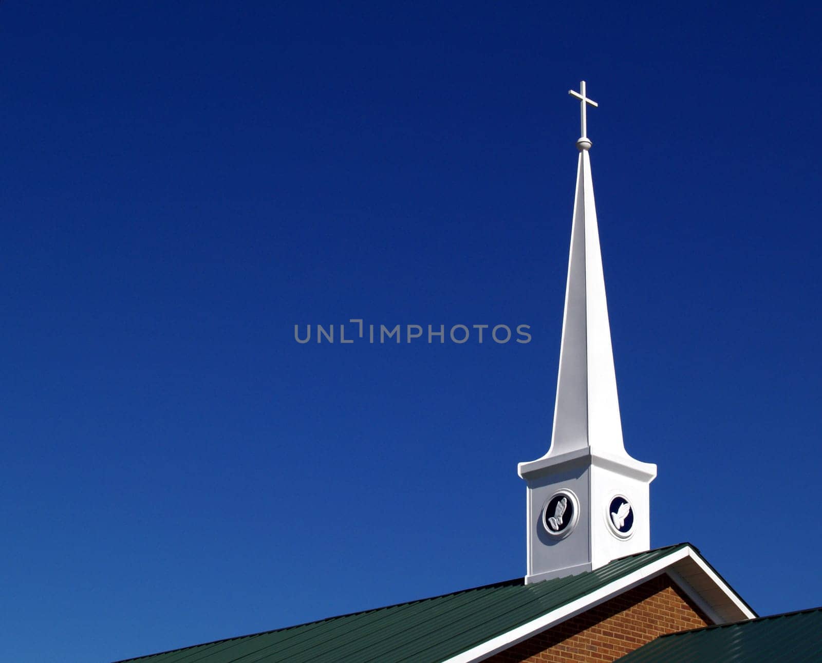 Church steeple with praying hands and space for copy.