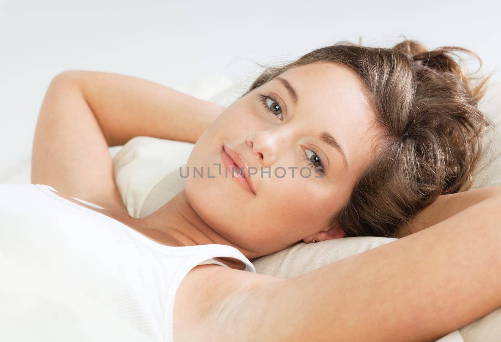 Pretty young awake woman lying in bed