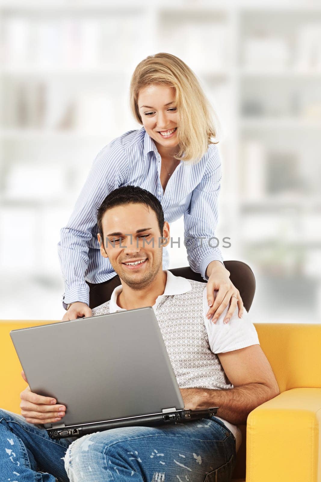 Happy young man and woman sitting together and looking at computer screen