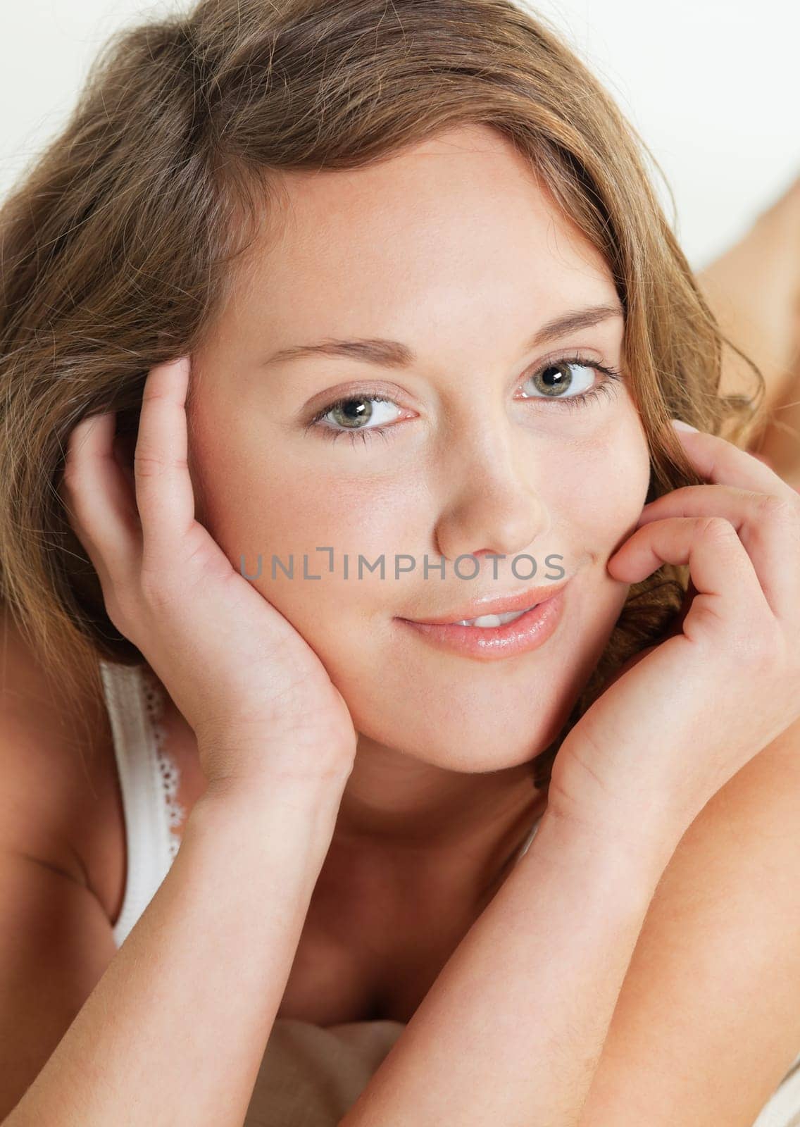 Closeup portrait of a pretty young woman lying in her bed