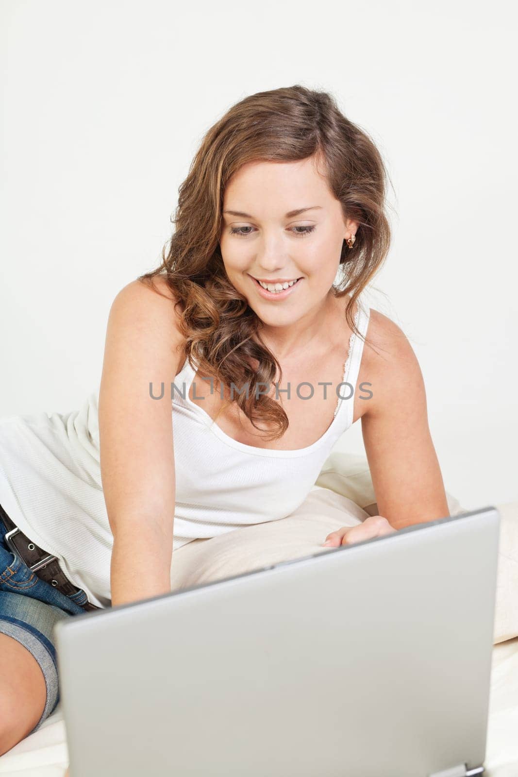 Pretty young woman her bed with laptop computer