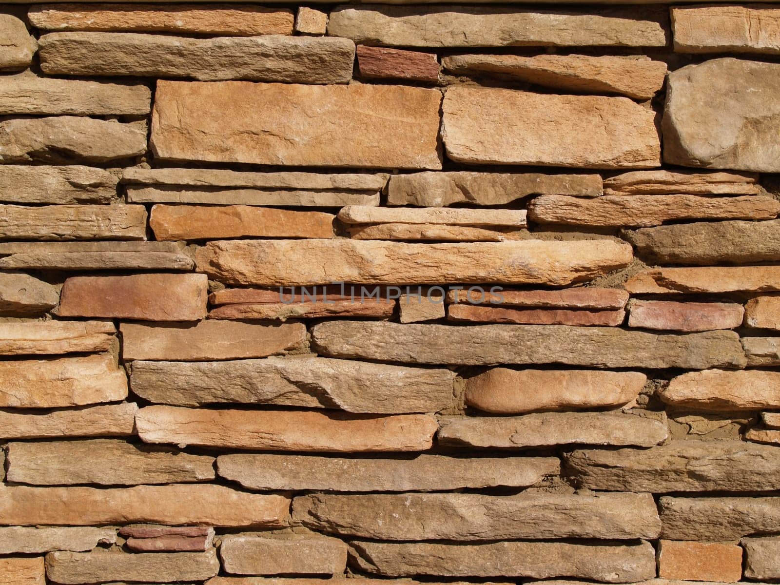 Flat, tan stones layered into a wall