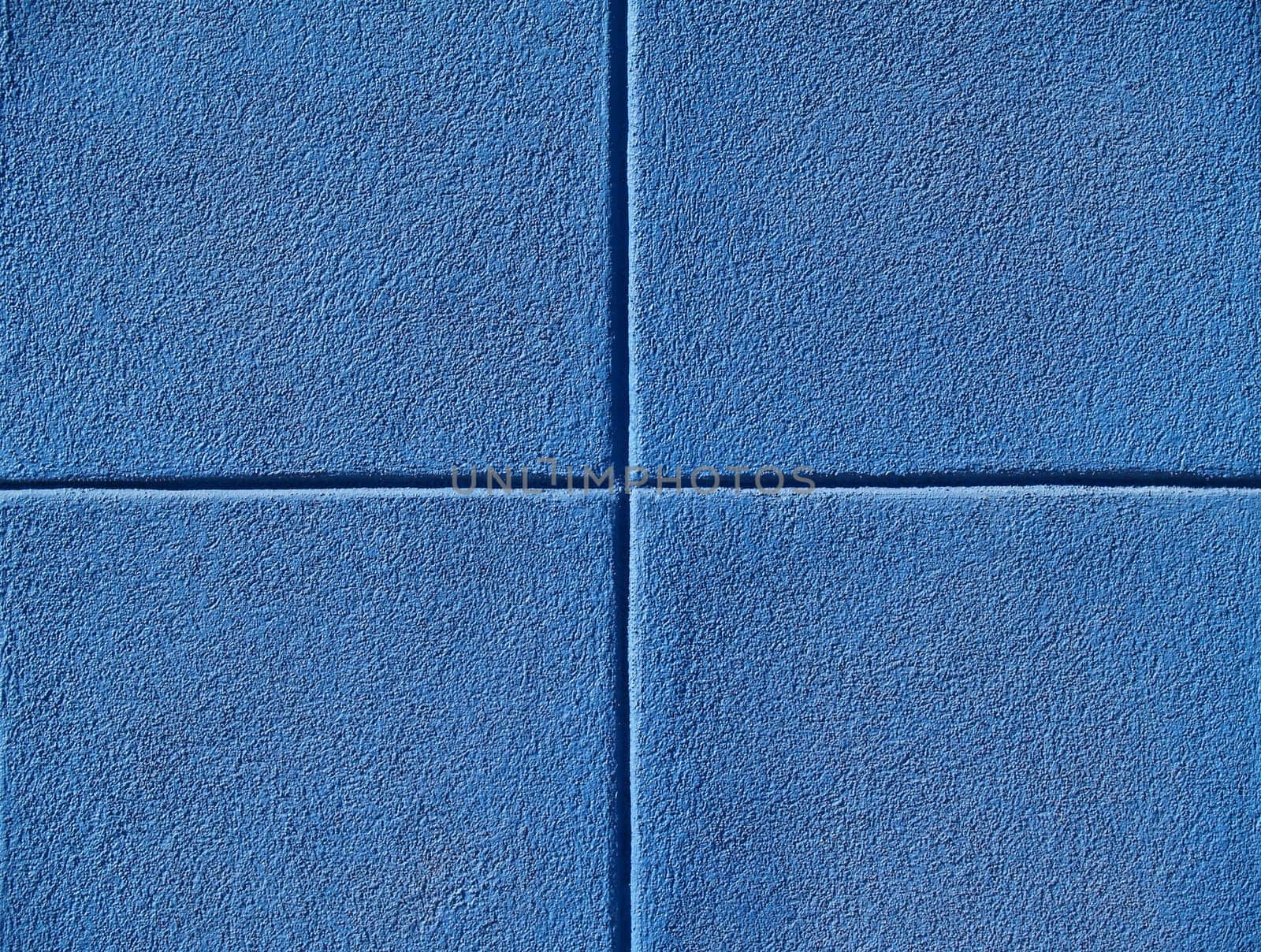 Four blue squares on a concrete wall, powerpoint background and copy space.
