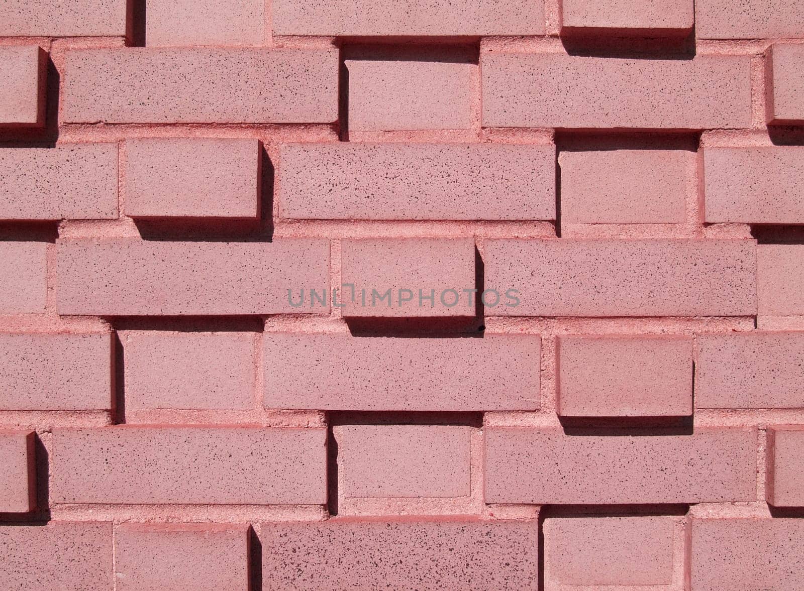 Pink  multi-layered and multi-sized painted brick wall.