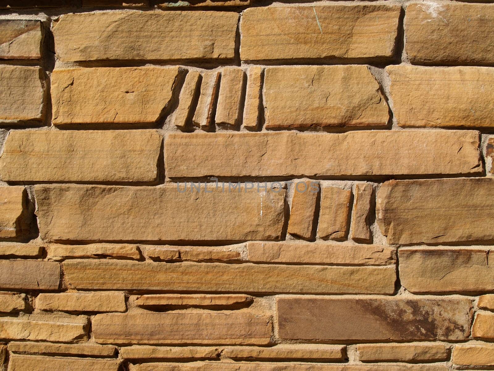 Tan colored wall with multi-sized flat layered stones
