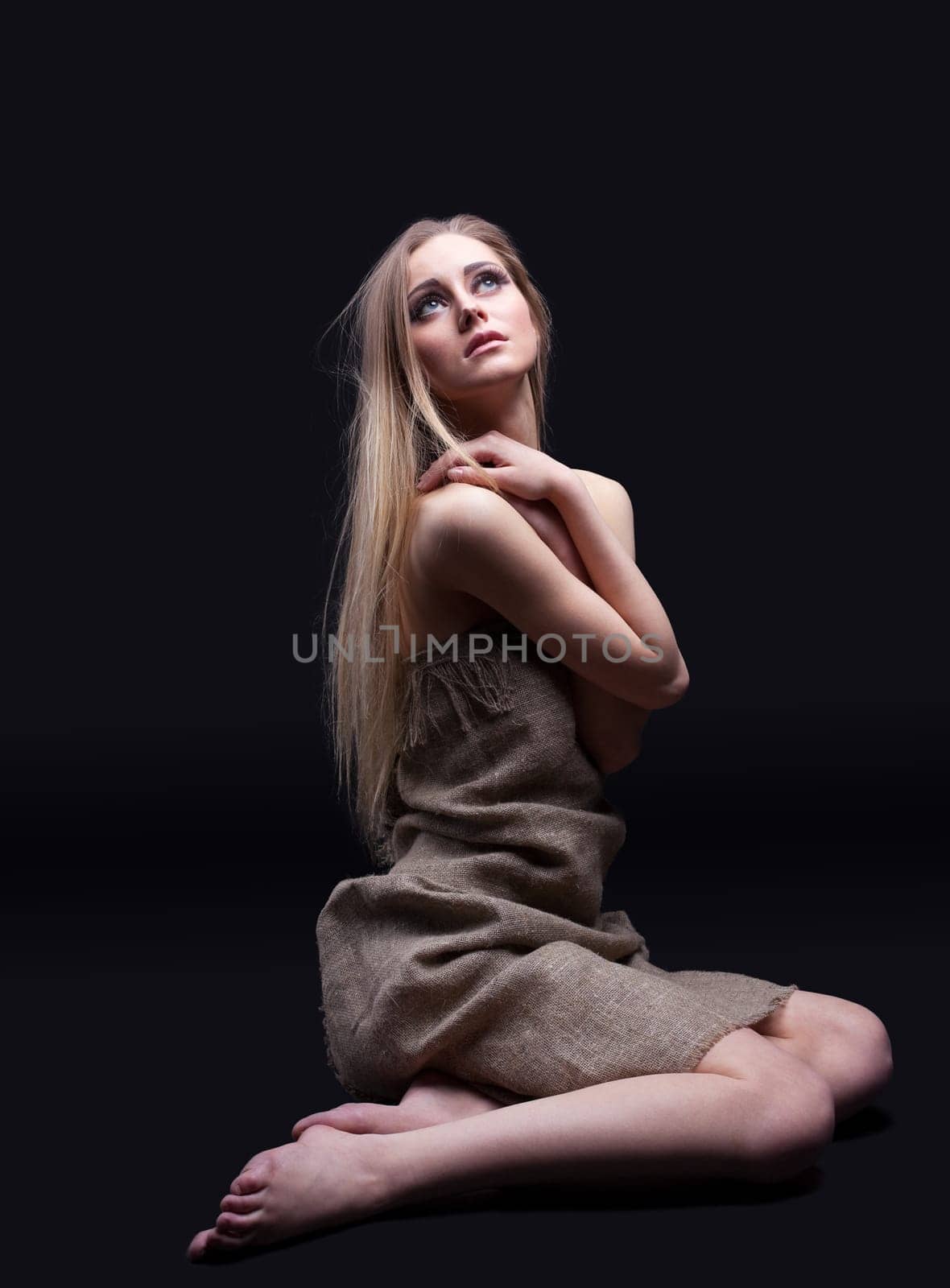 Young girl in sadness look from dark on light with hope