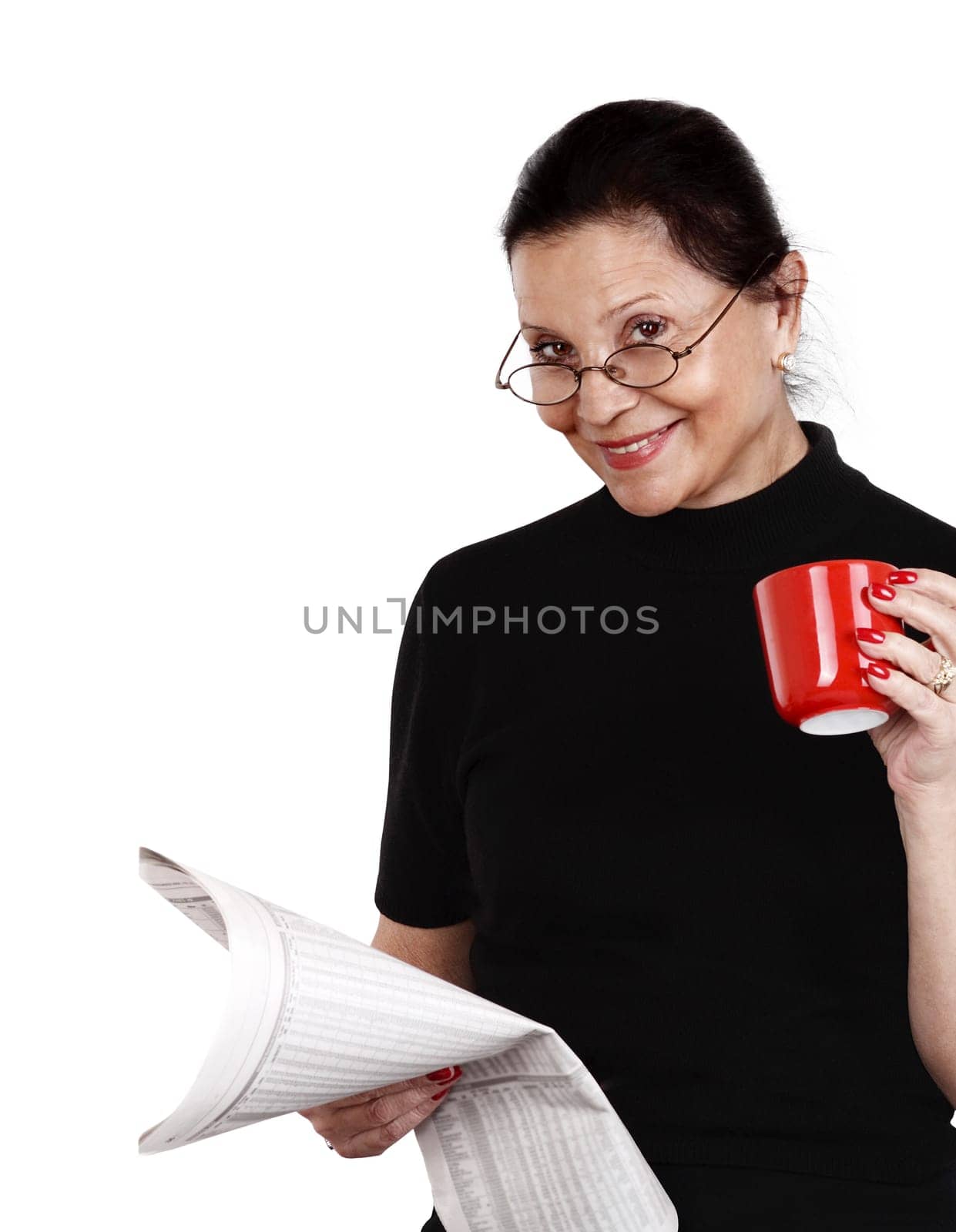 woman looks at newspaper and drinks her coffee against white background