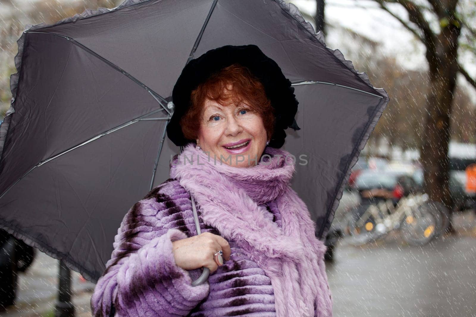 Senior woman Laughing standing in front with umbrella, street background