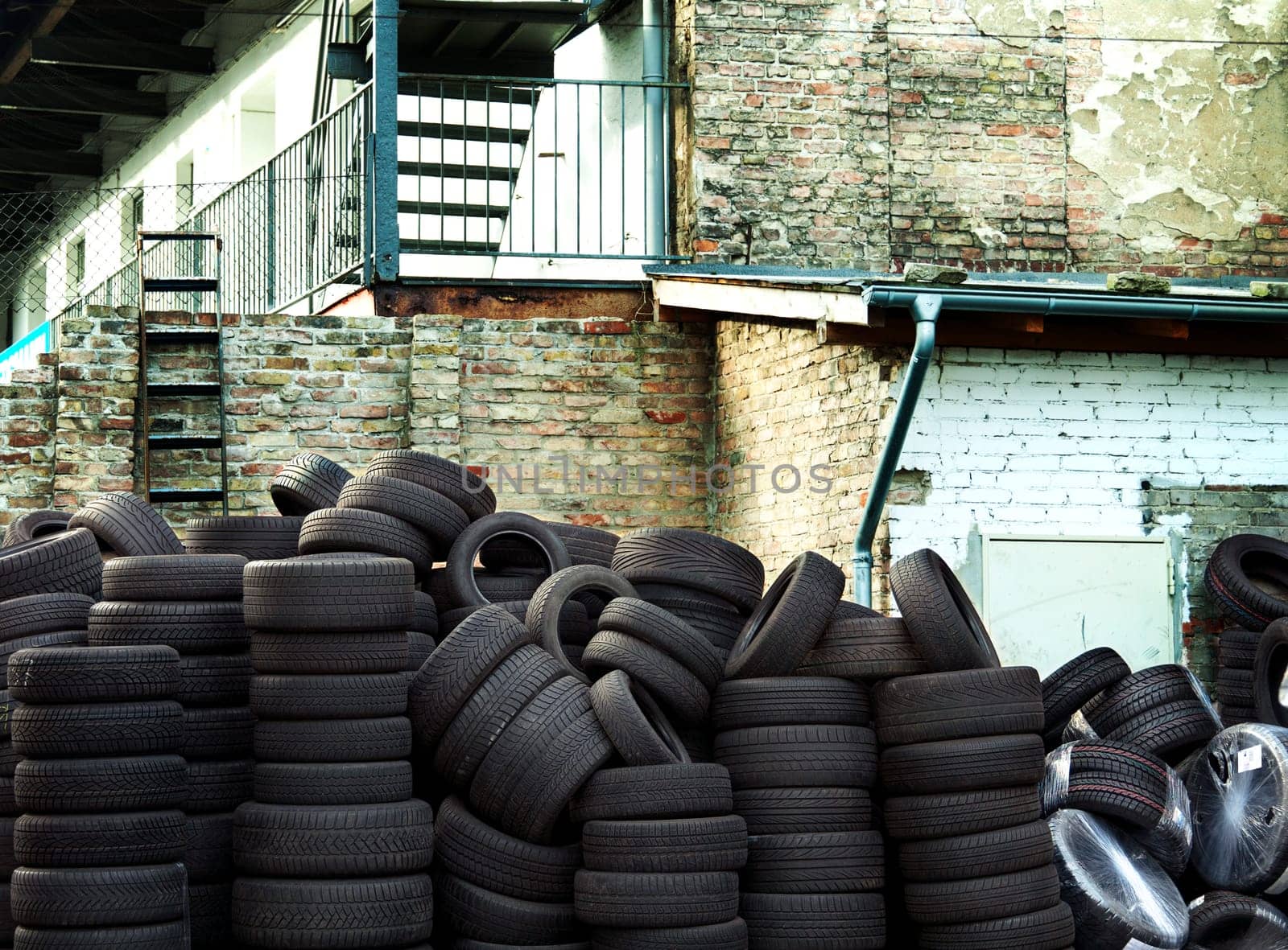 Wall of old car tires with old Brick Wall in the background