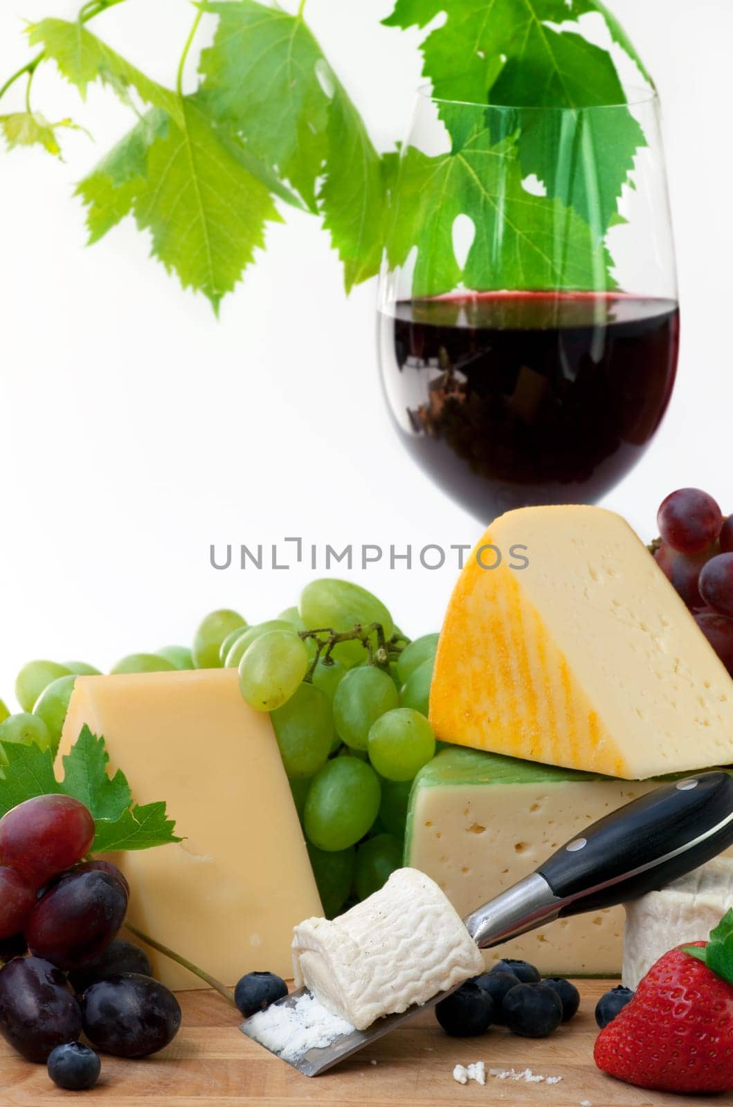 Glass of red wine and assorted cheeses with Fruit