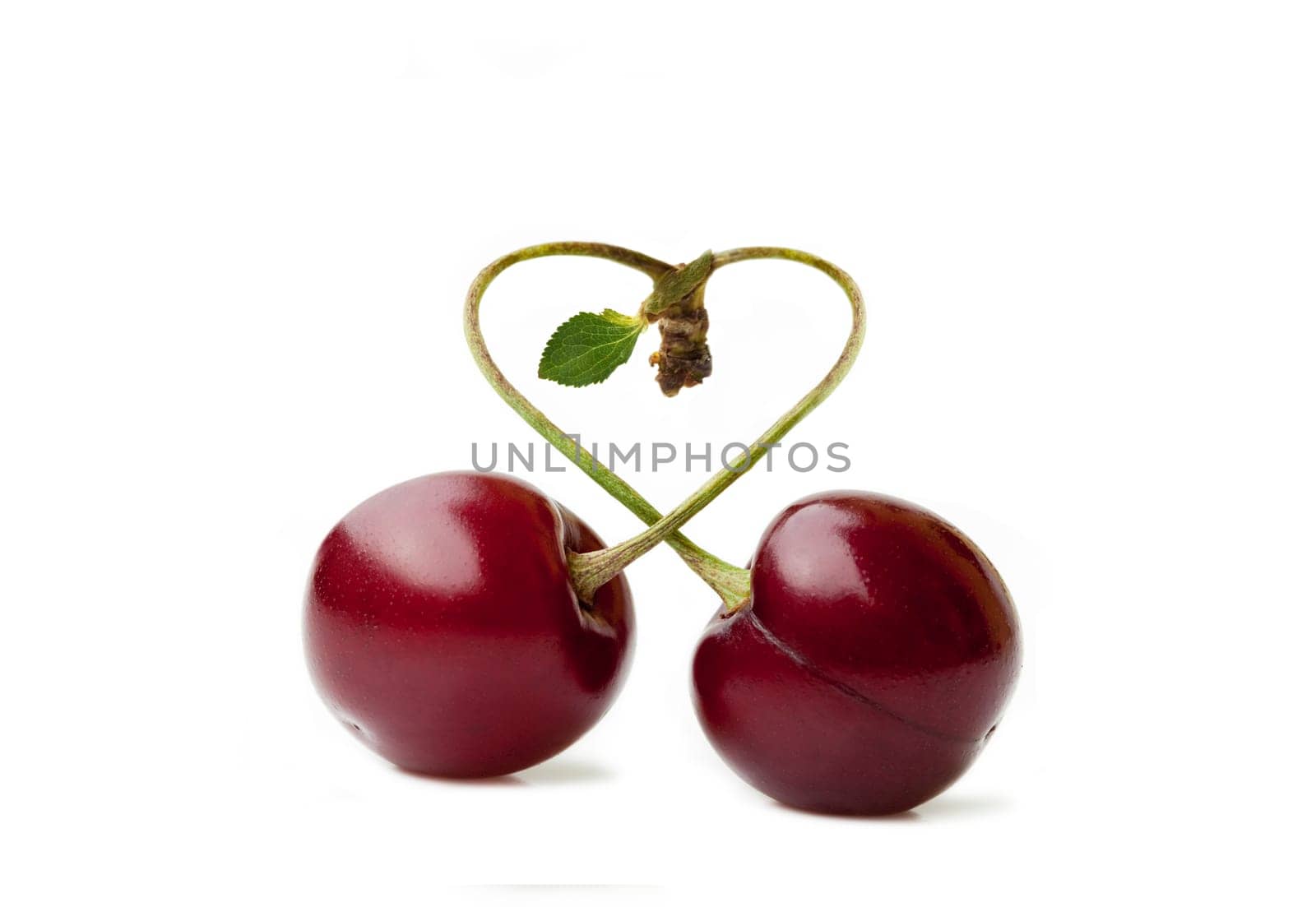 Two cherries with a stem in the shape of a heart cut out
