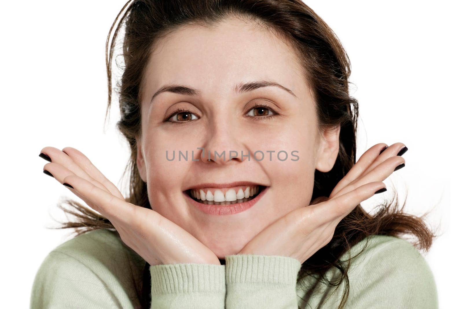 Happy young woman smiling with friendly look,hands on chin