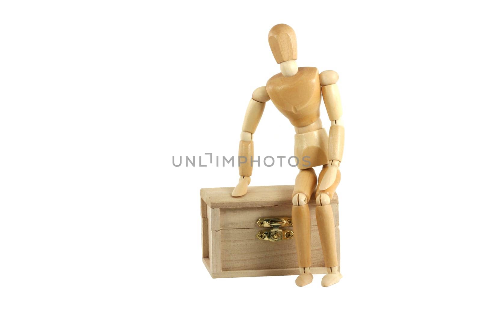 A Wooden manikin sitting on treasure chest