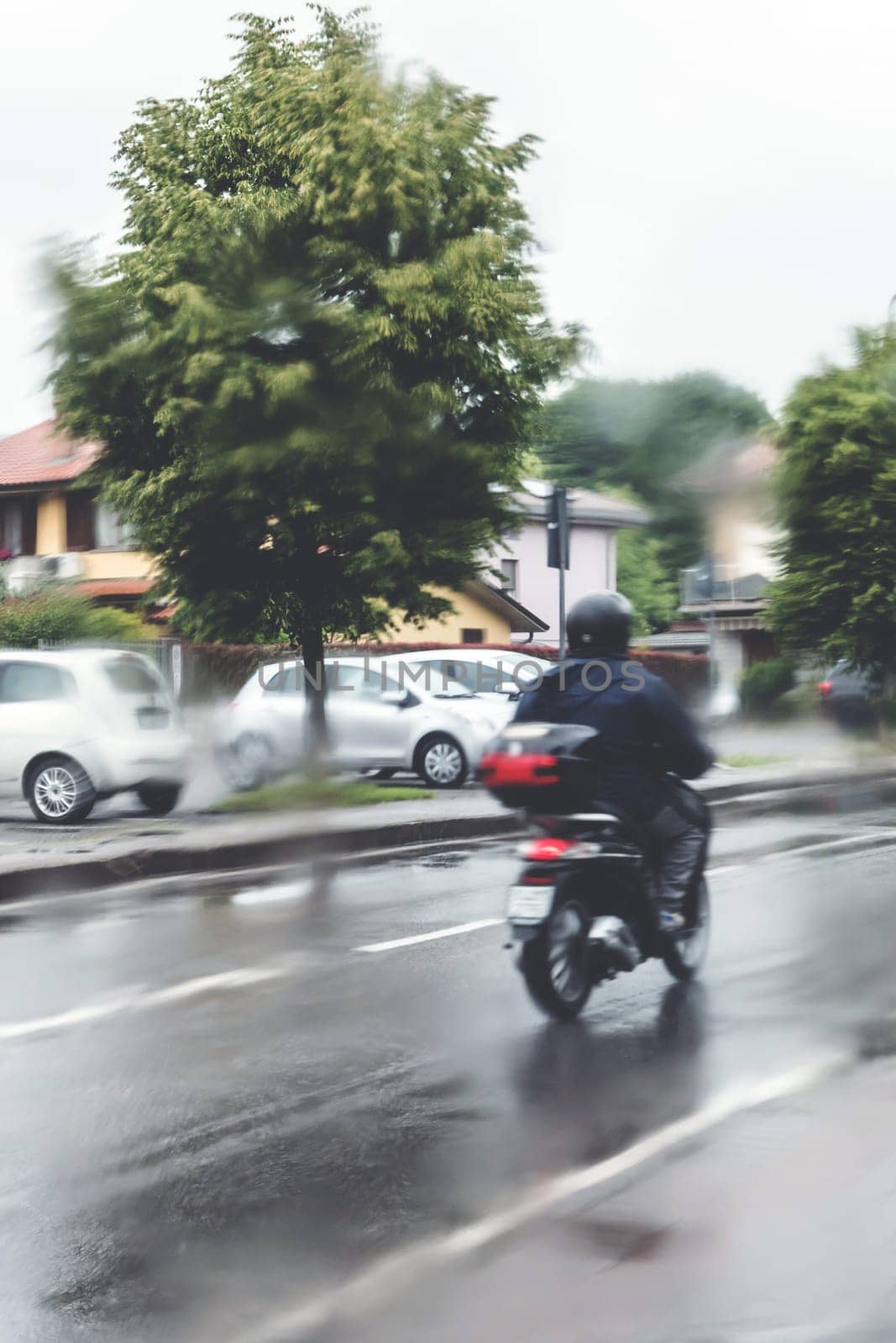 Man in the rain with his motorcycle by germanopoli