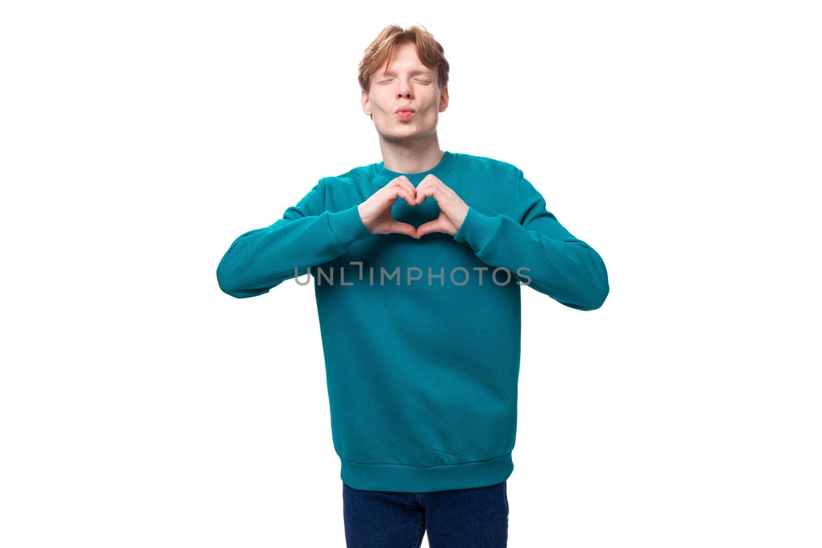 young caucasian student guy with red hair in a blue sweater shows a heart by TRMK