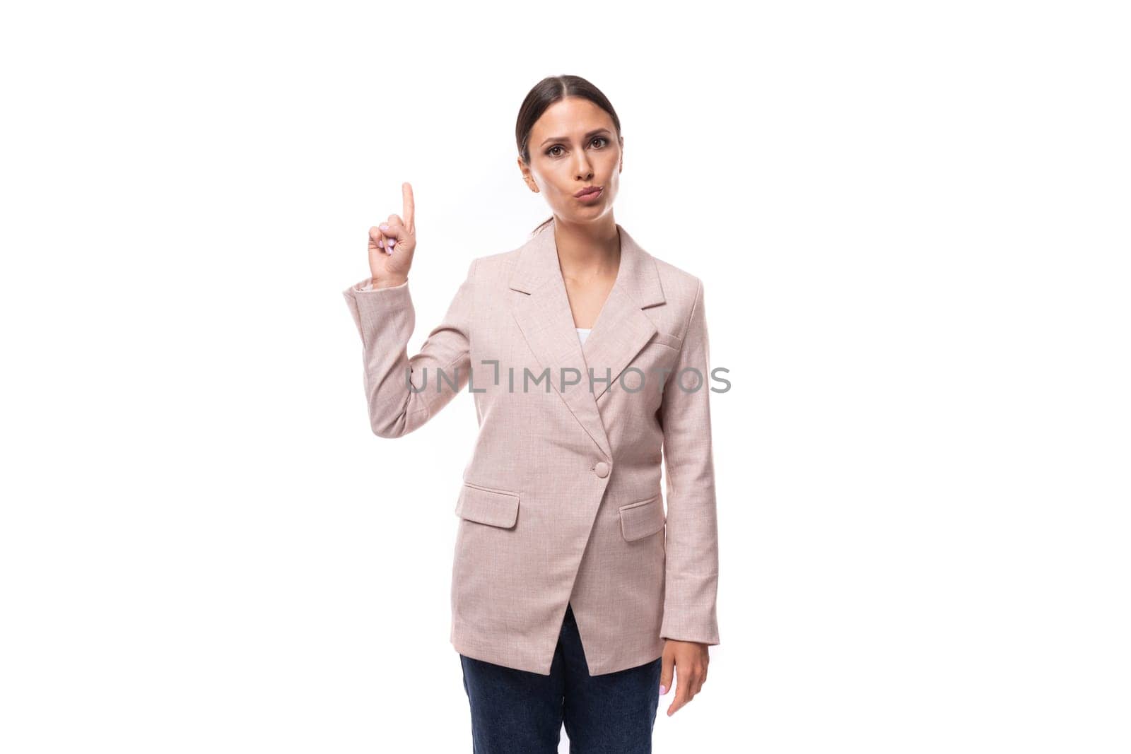 pleasant young woman with black hair in a jacket stands thoughtfully on a white background with copy space.