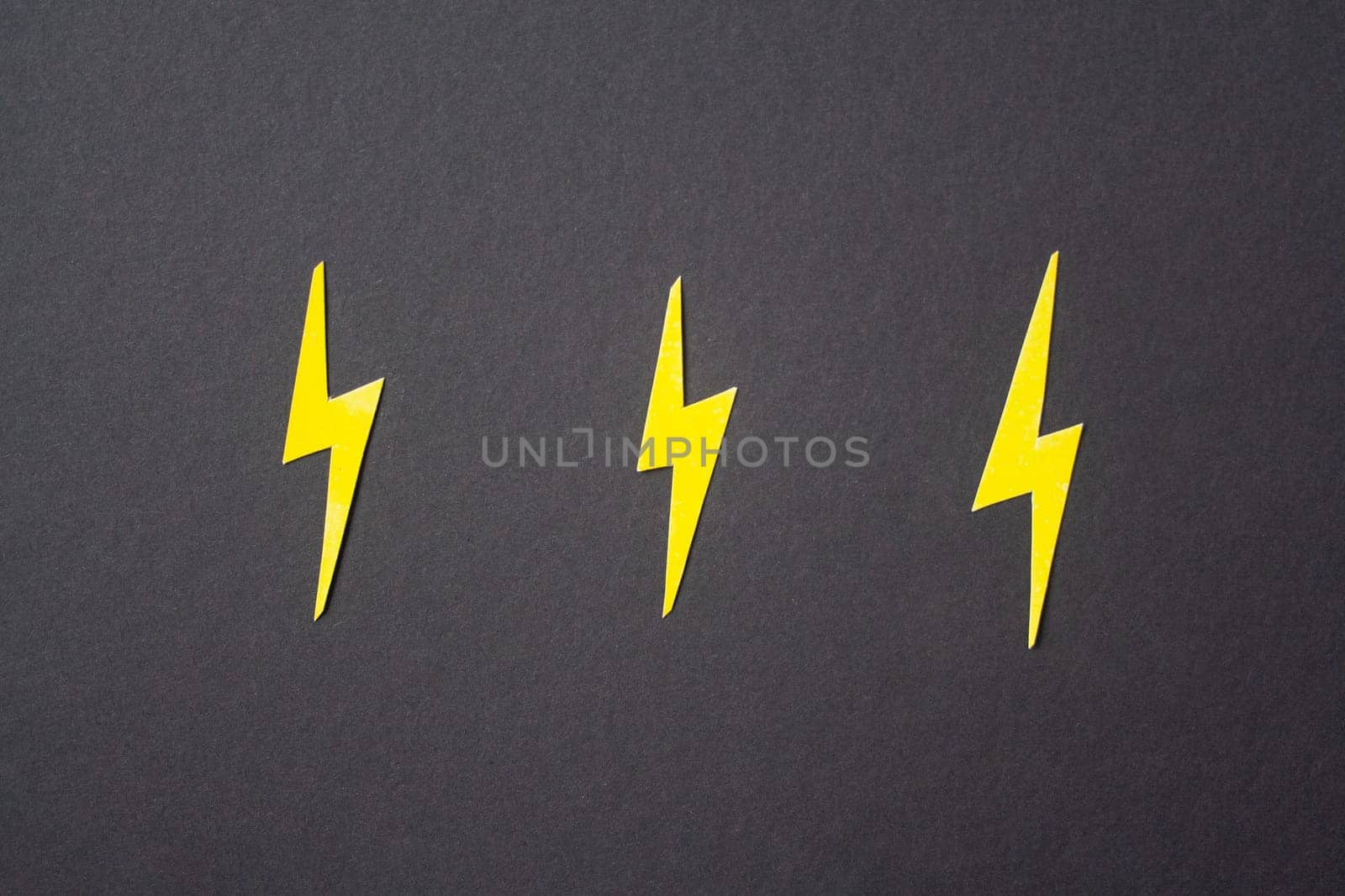 Yellow cut out lightings on black background. Idea concept. Energy and electricity. Innovation and thinking out the box symbols. Creativity and inspiration
